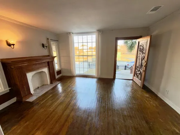 a view of a livingroom with wooden floor and a fireplace
