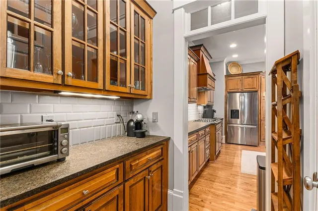 a kitchen with stainless steel appliances kitchen island granite countertop a table chairs sink and cabinets