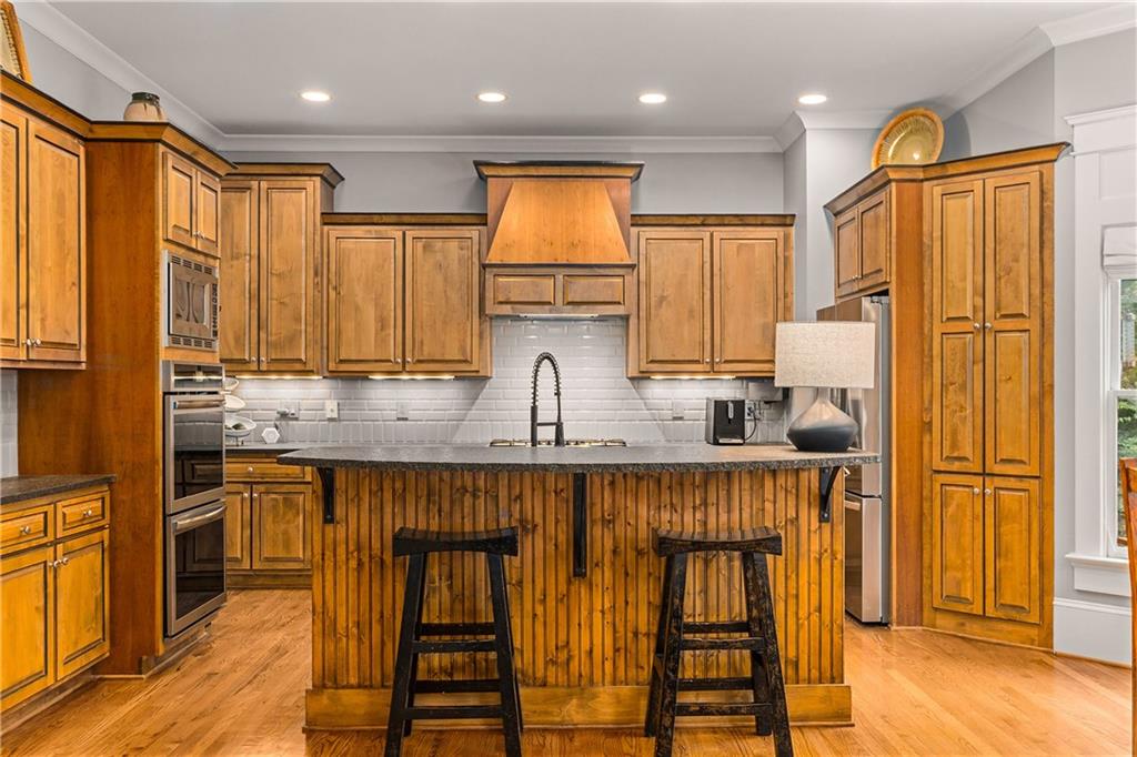 280 Sutherland Place Northeast Atlanta, GA 30307 - Photo 16 of 66 a kitchen with stainless steel appliances granite countertop a refrigerator and wooden cabinets