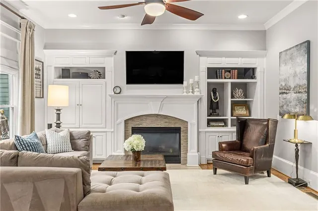 a living room with furniture kitchen area and a large window