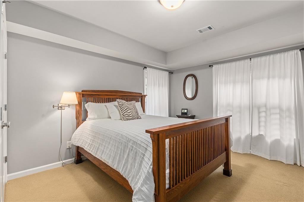 280 Sutherland Place Northeast Atlanta, GA 30307 - Photo 41 of 66 a bedroom with a bed and dresser with mirror