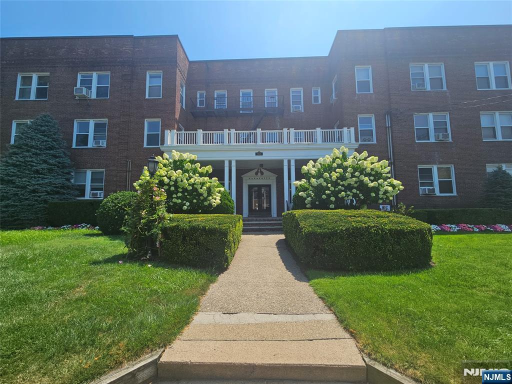 a front view of a brick building with a yard