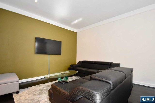 985 Teaneck Road, Unit 1J Teaneck, NJ 07666 - Photo 5 of 10 a living room with furniture and a flat screen tv