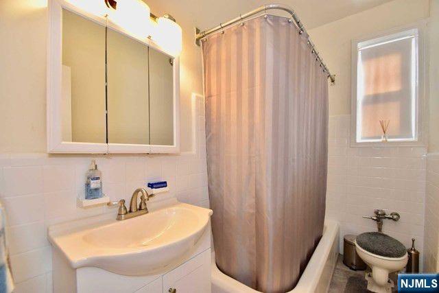 985 Teaneck Road, Unit 1J Teaneck, NJ 07666 - Photo 9 of 10 a bathroom with a sink a toilet and a mirror