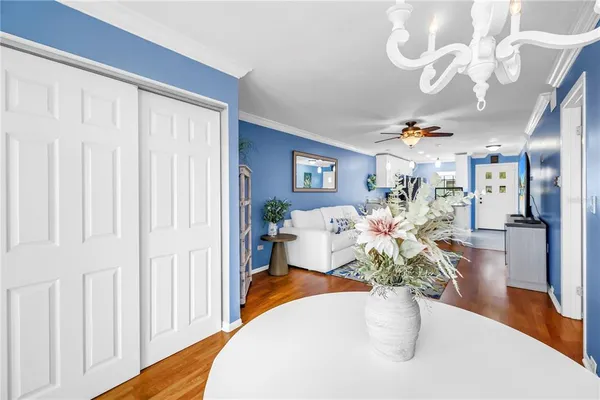 a dining room with furniture a potted plant and wooden floor