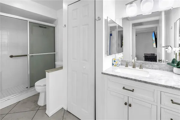 a bathroom with a granite countertop sink toilet and shower