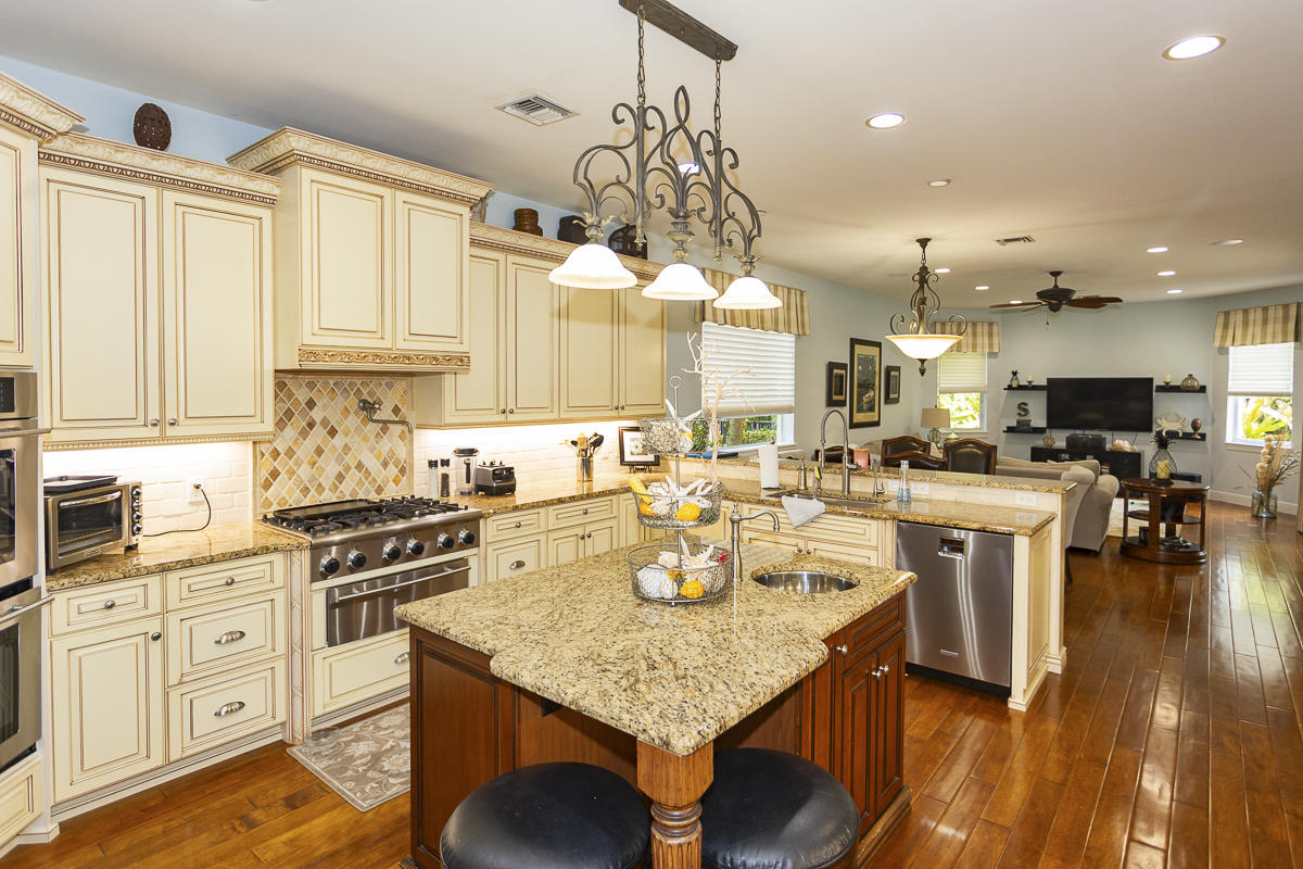 1301 Southwest 16th Street Boca Raton, FL 33486 - Photo 3 of 57 a kitchen with stainless steel appliances kitchen island granite countertop a lot of counter space and wooden floors