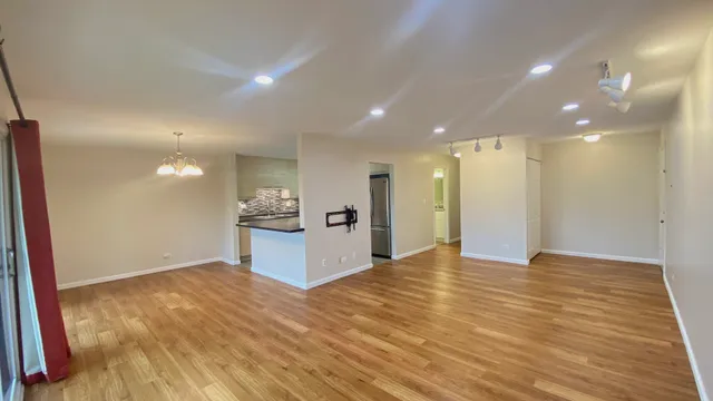 a view of a kitchen with kitchen island wooden floor center island and stainless steel appliances