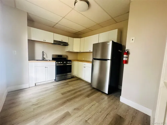 a kitchen with stainless steel appliances granite countertop a refrigerator and a stove top oven