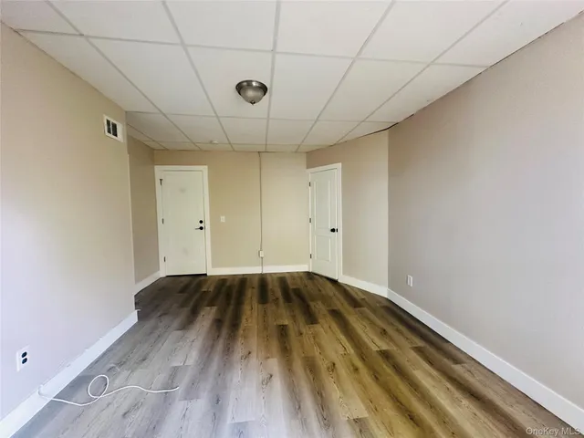 a view of a room with wooden floor and a ceiling fan