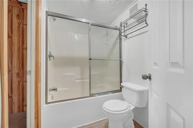 a bathroom with a granite countertop toilet and a sink