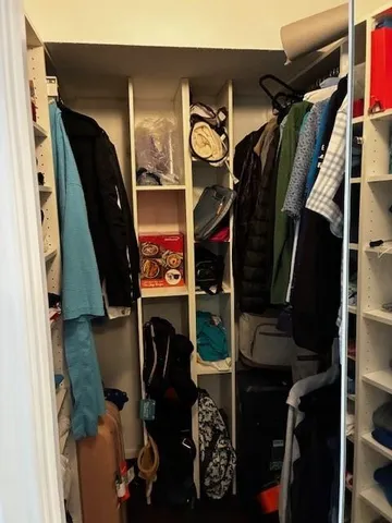 a view of walk in closet with clothes and shoes