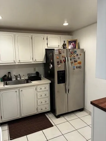 a view of a kitchen with refrigerator and cabinets