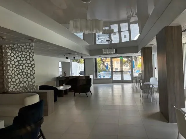 a living room with couches and kitchen view with wooden floor