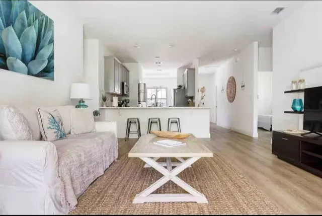 a living room with furniture and a wooden floor