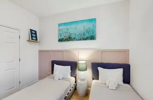 a bedroom with a bed and a painting on the wall