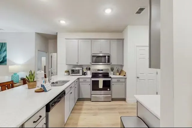 a kitchen with white cabinets and stainless steel appliances