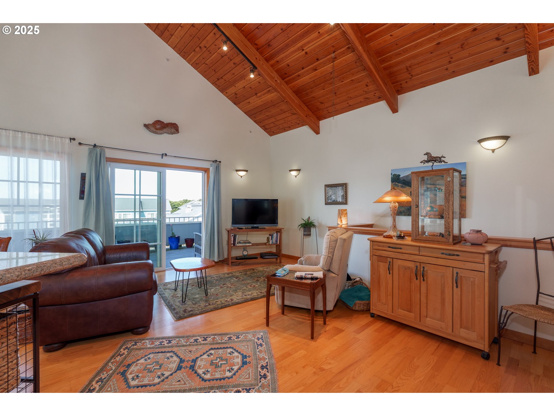 1327 Village Loop Bandon, OR 97411 - Photo 12 of 38 a living room with furniture a rug and a fireplace