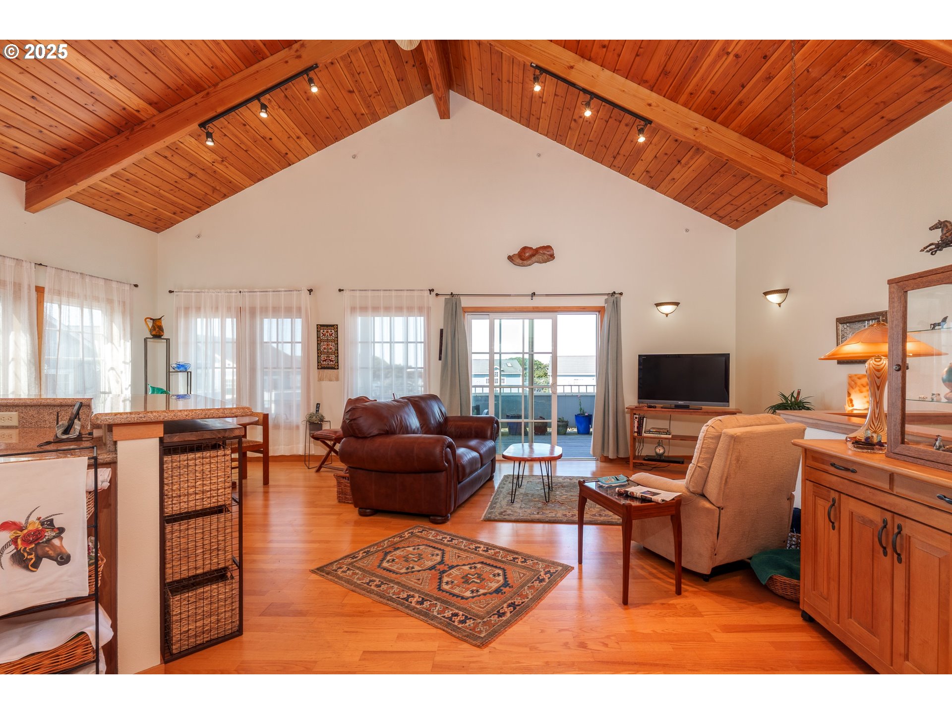 1327 Village Loop Bandon, OR 97411 - Photo 16 of 38 a living room with furniture a flat screen tv and a table