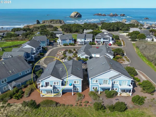 an aerial view of residential houses with outdoor space and ocean view
