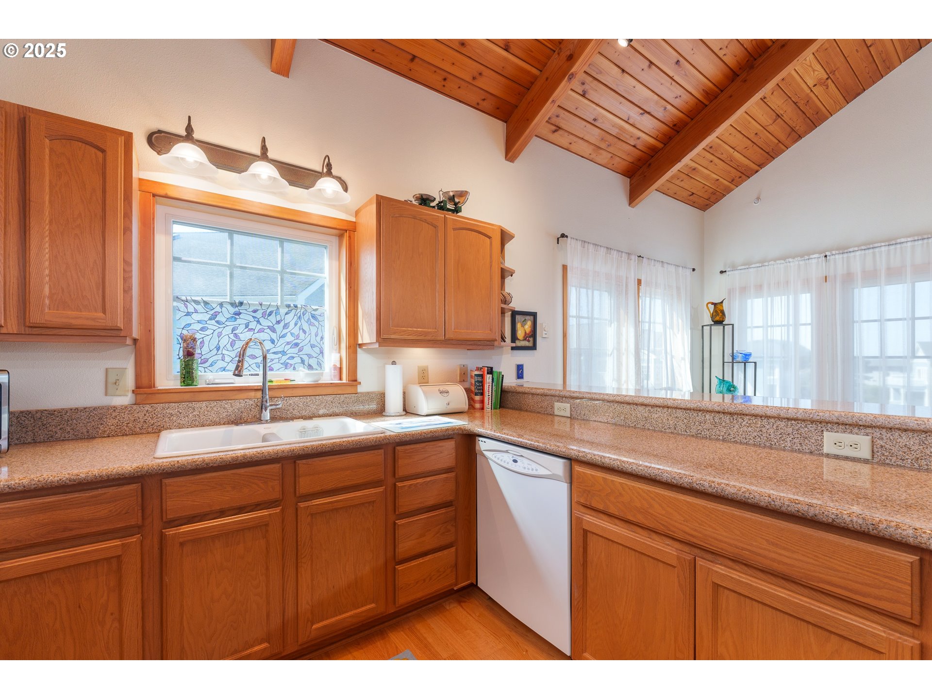 1327 Village Loop Bandon, OR 97411 - Photo 8 of 38 a kitchen with a sink cabinets and a large window