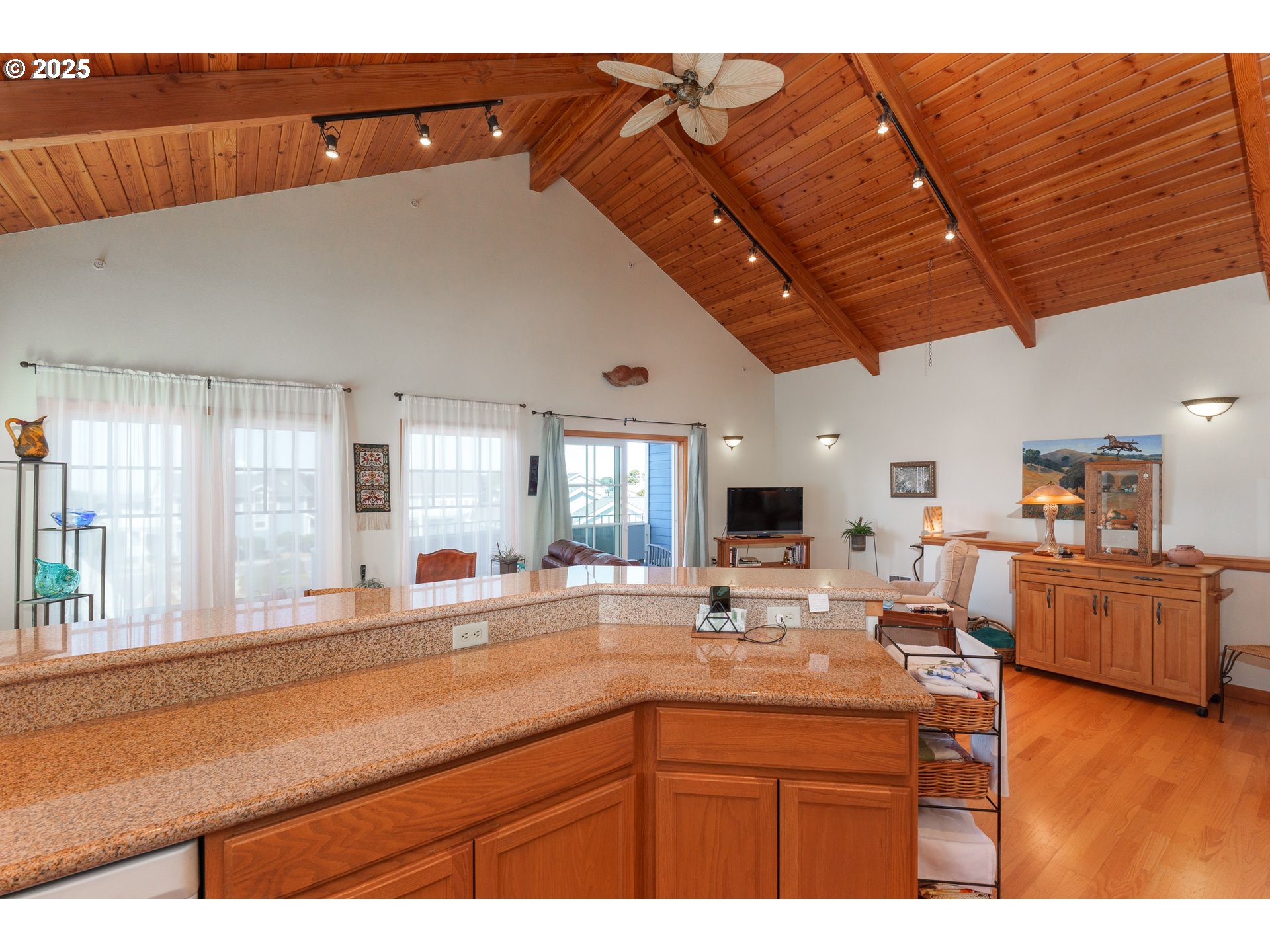 1327 Village Loop Bandon, OR 97411 - Photo 9 of 38 a kitchen with stainless steel appliances granite countertop a sink dishwasher and cabinets with wooden floor