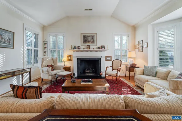 a living room with furniture fireplace and a large window