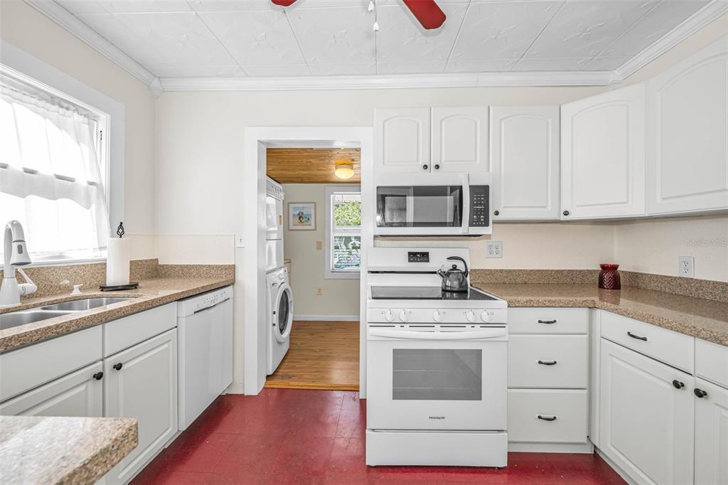 525 Bay Street Dunedin, FL 34698 - Photo 13 of 38 a kitchen with granite countertop white cabinets and white appliances