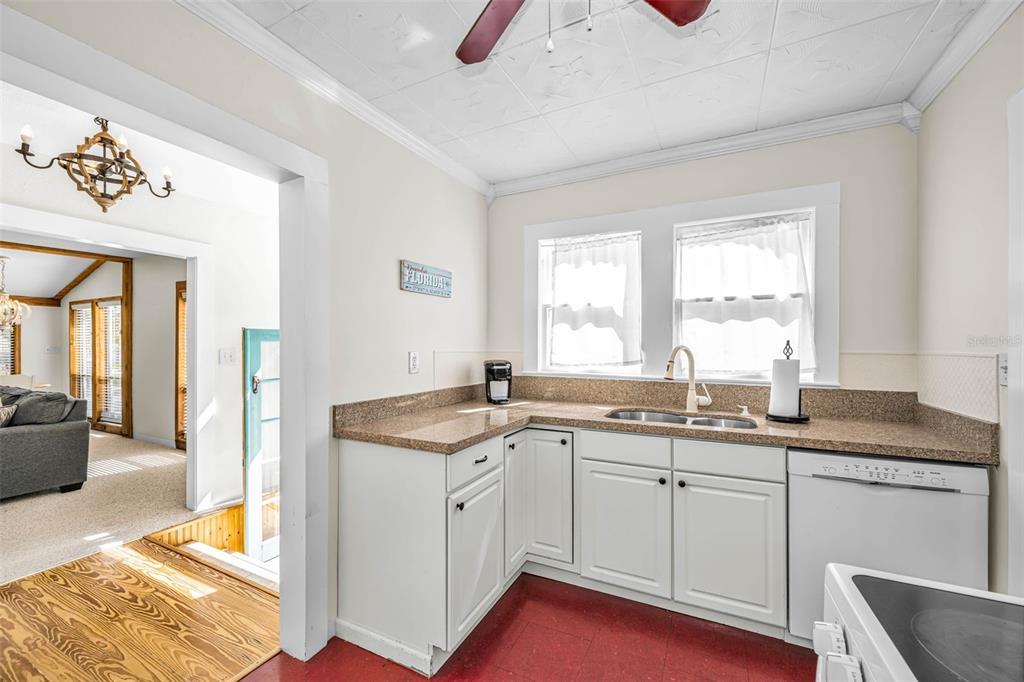 525 Bay Street Dunedin, FL 34698 - Photo 14 of 38 a kitchen with granite countertop cabinets a sink a dining table and chairs
