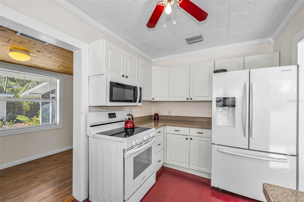 525 Bay Street Dunedin, FL 34698 - Photo 16 of 38 a kitchen with white cabinets and white appliances