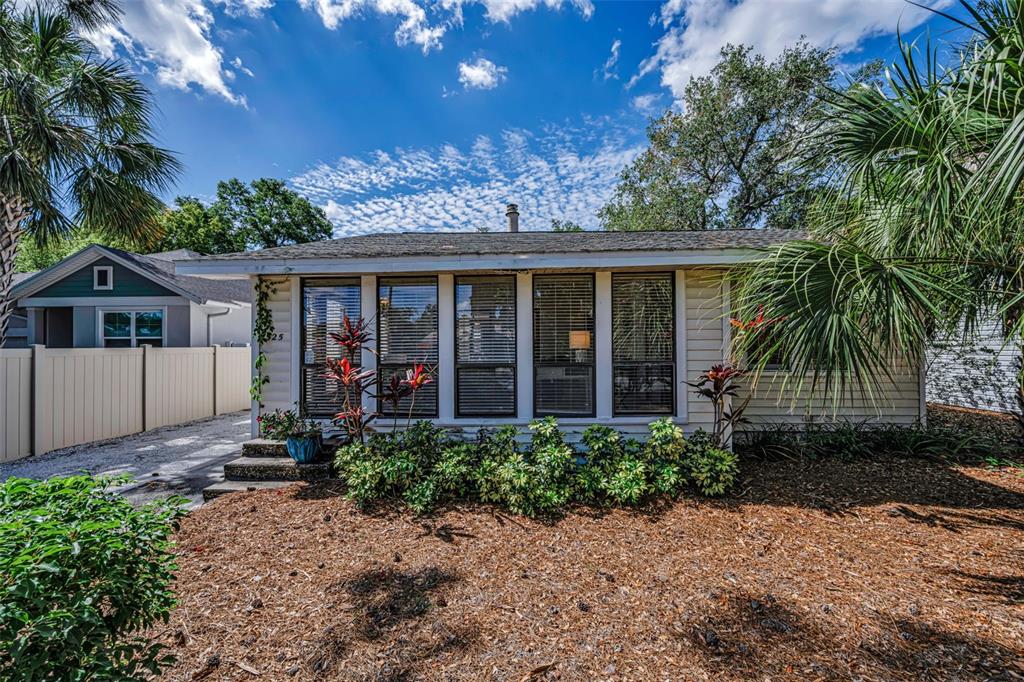 525 Bay Street Dunedin, FL 34698 - Photo 32 of 38 a view of a house with a yard and potted plants