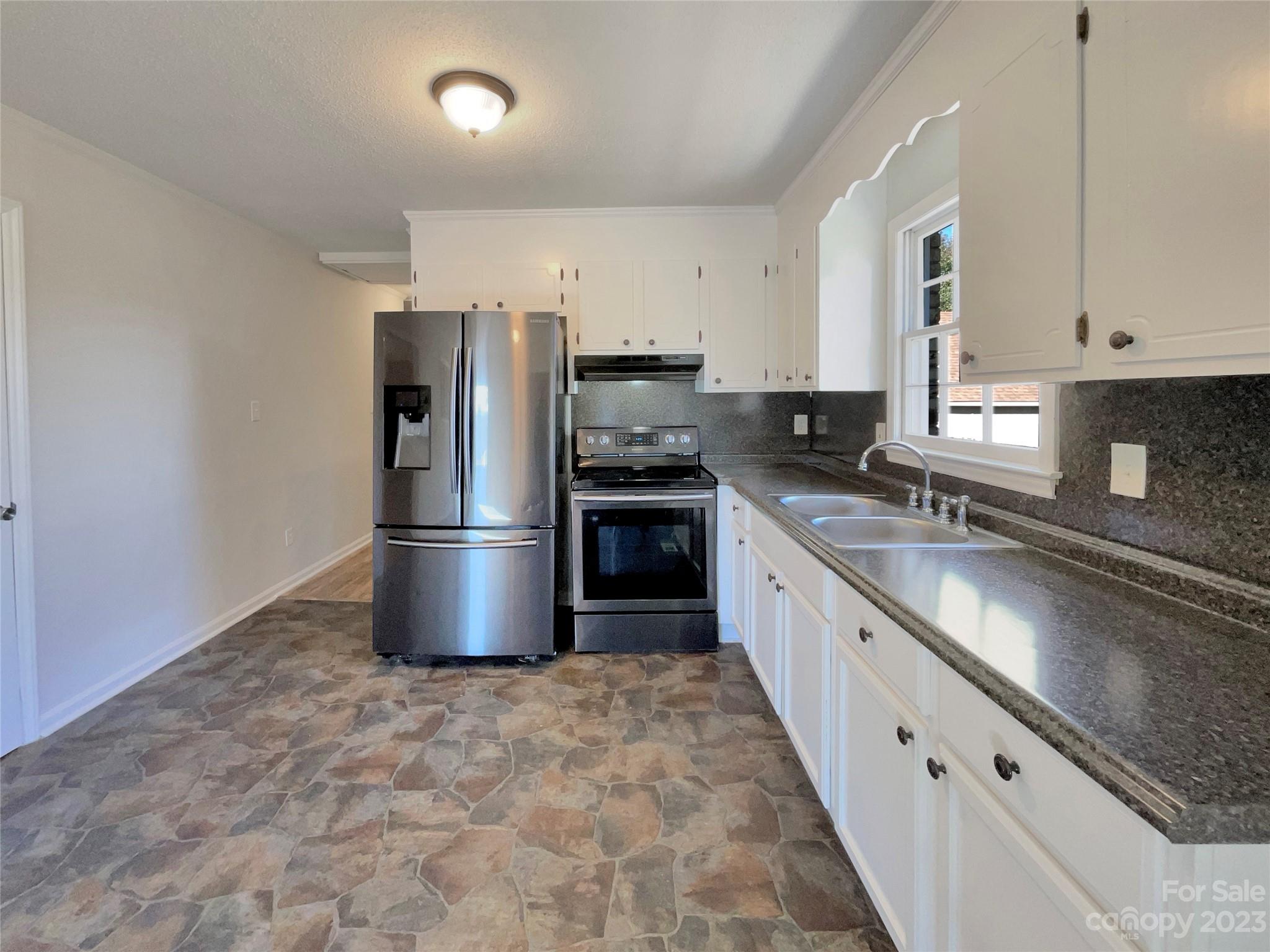1904 Bess Town Road Bessemer City, NC 28016 - Photo 11 of 18 a large kitchen with stainless steel appliances granite countertop a stove a sink and a refrigerator