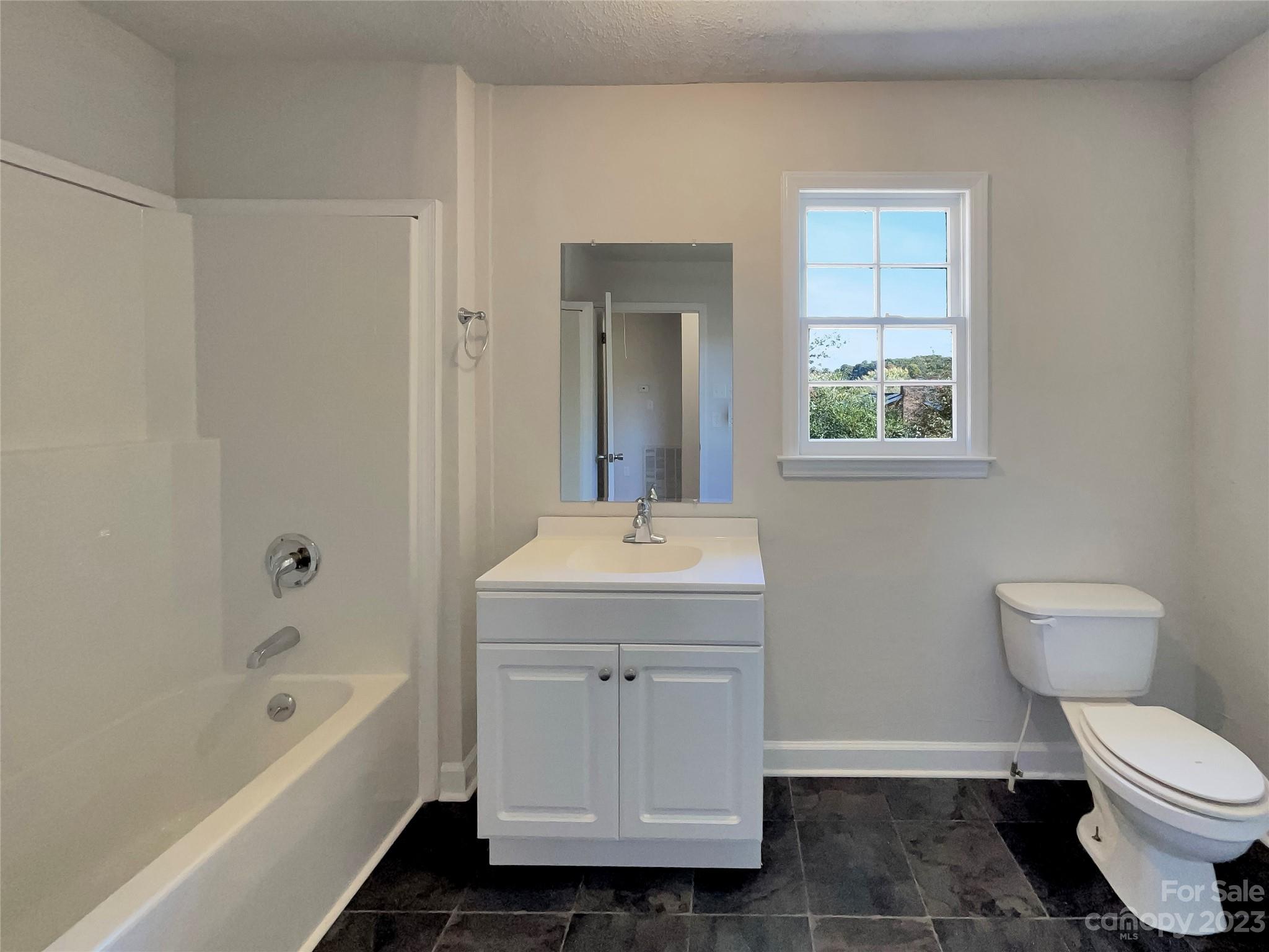 1904 Bess Town Road Bessemer City, NC 28016 - Photo 12 of 18 a bathroom with a granite countertop sink a toilet and bathtub