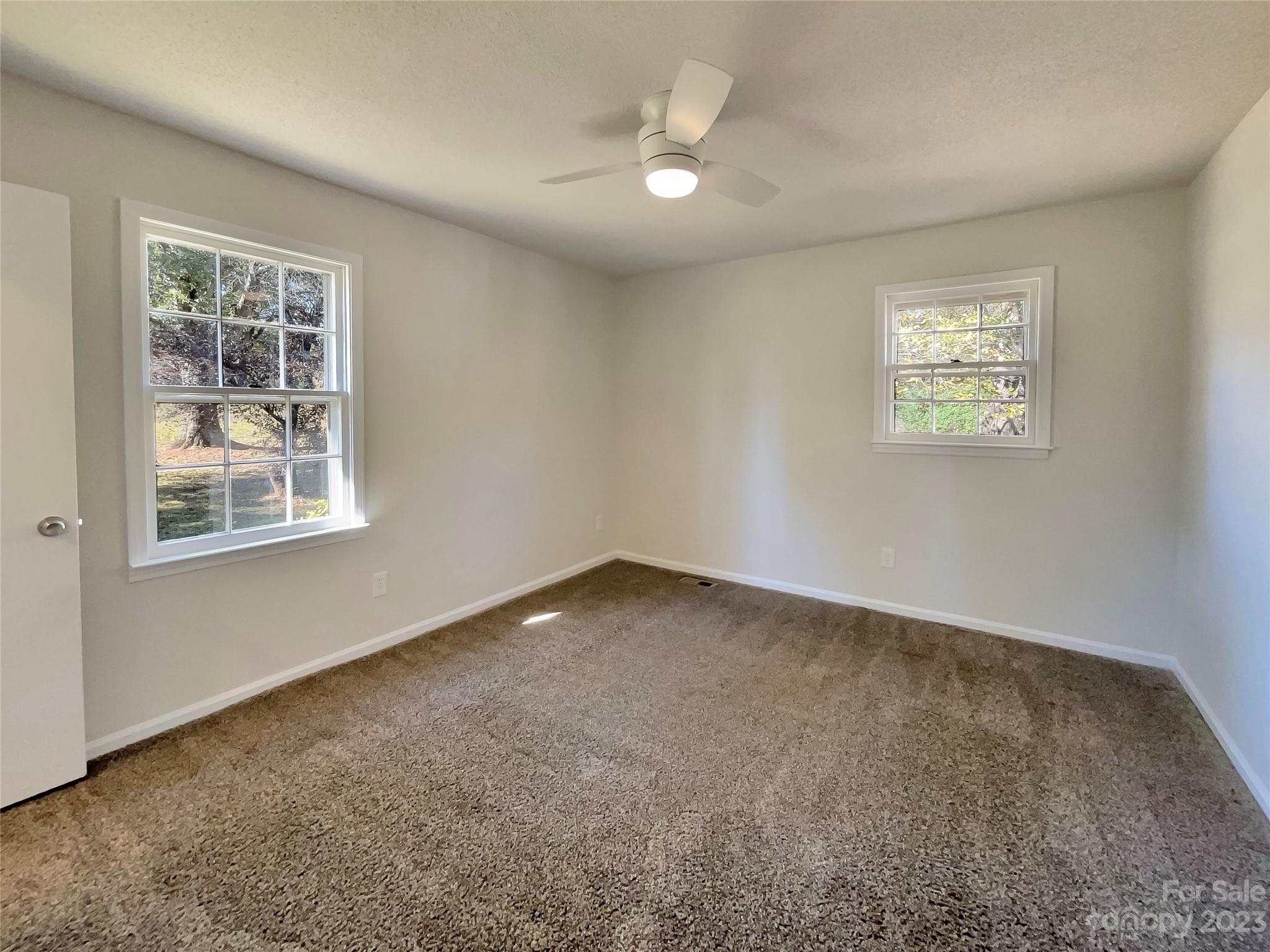 1904 Bess Town Road Bessemer City, NC 28016 - Photo 5 of 18 an empty room with windows and fan