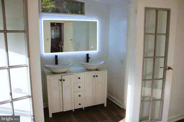 a bathroom with a granite countertop sink and a mirror