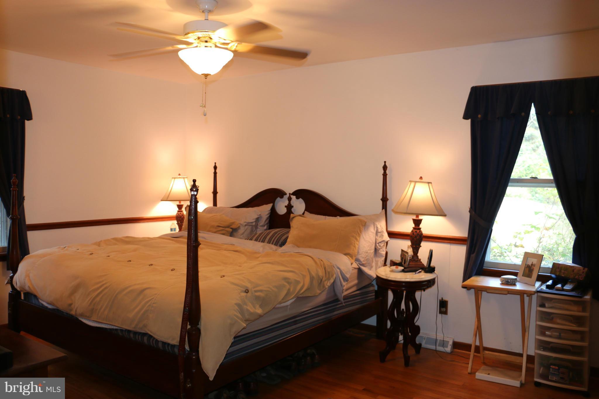 13831 Manor Road Baldwin, MD 21013 - Photo 5 of 20 a bedroom with a bed and a chandelier