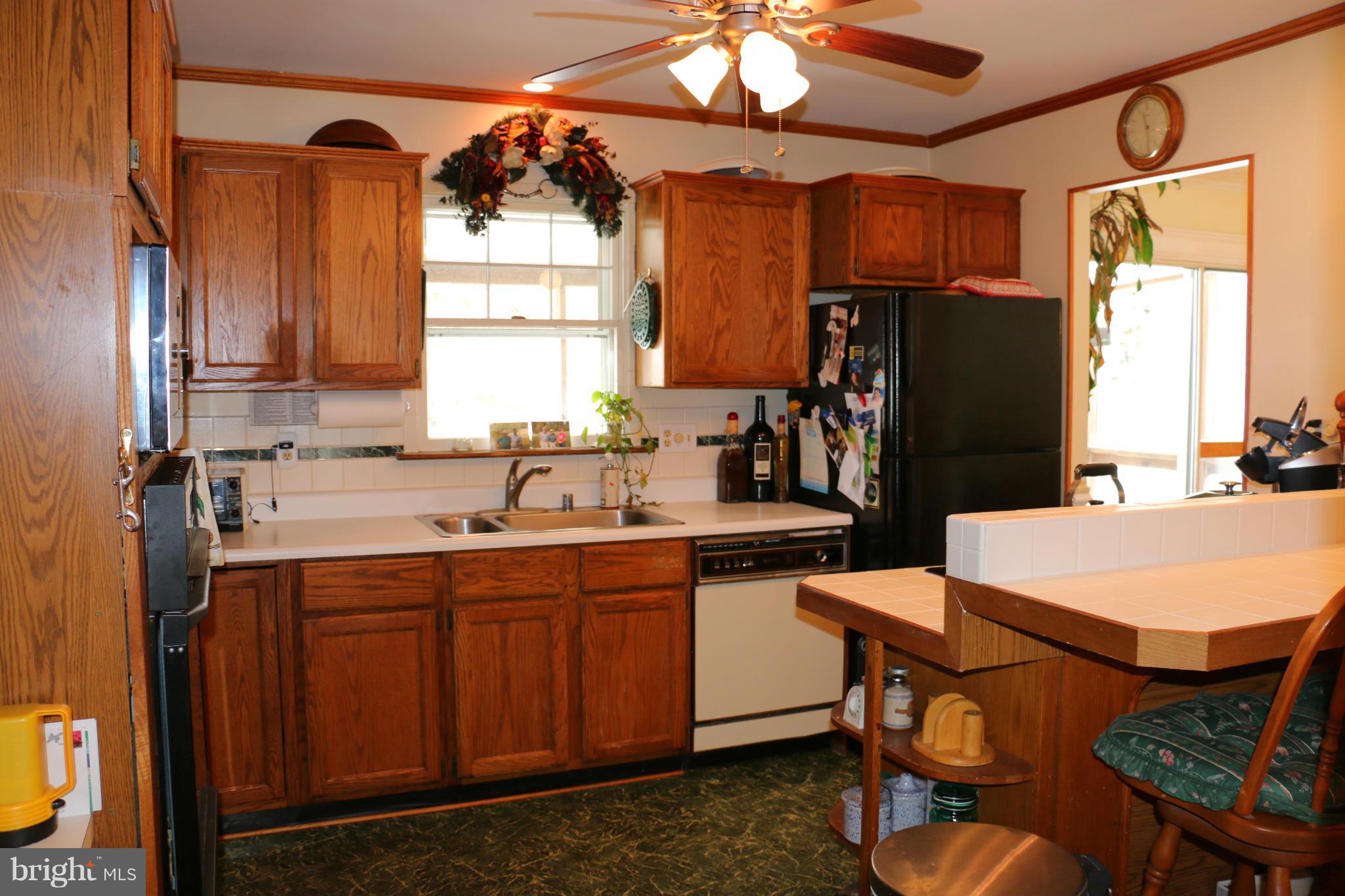 13831 Manor Road Baldwin, MD 21013 - Photo 7 of 20 a kitchen with stainless steel appliances a sink a stove a refrigerator cabinets and dining table