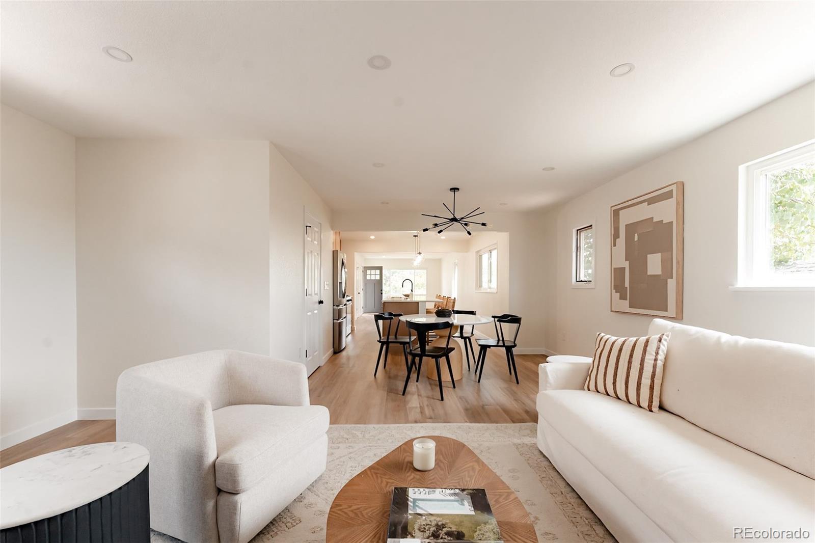 1279 South Raritan Street Denver, CO 80223 - Photo 9 of 25 a living room with furniture a dining table and a chandelier