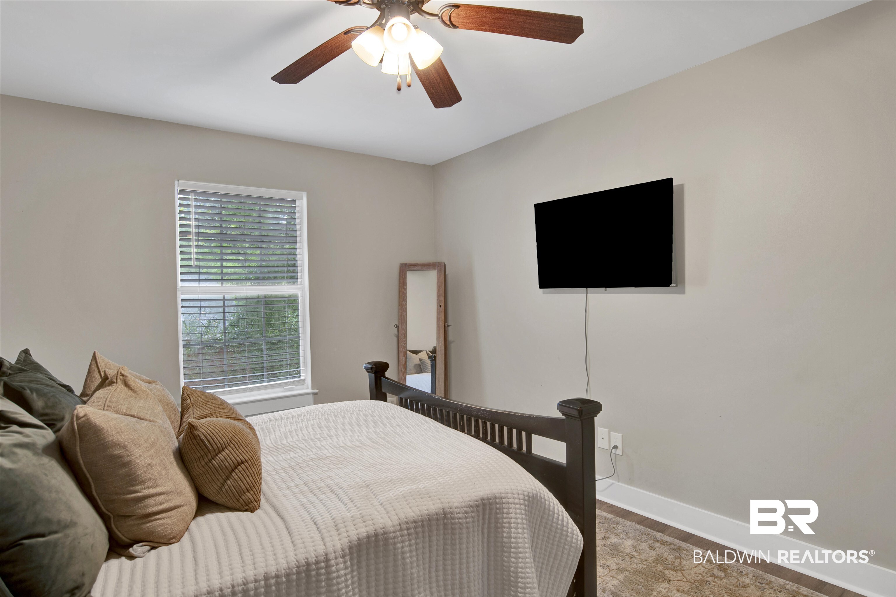 253 Maplewood Loop Daphne, AL 36526 - Photo 21 of 30 Neutral-toned room featuring a ceiling fan with wood-finish blades, a wall-mounted television, and a window with horizontal blinds