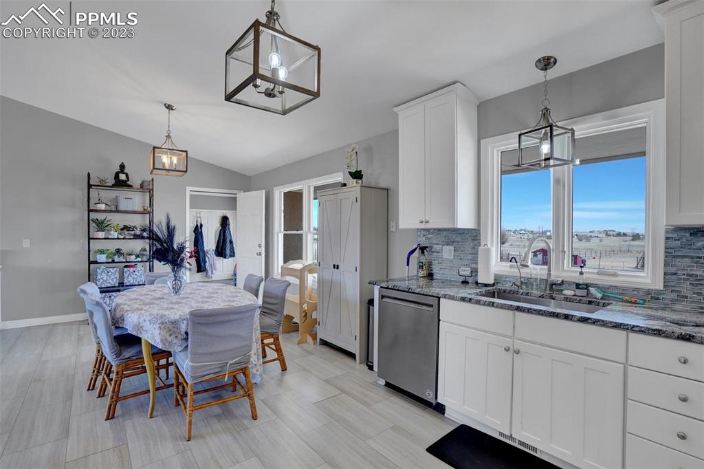 3805 Curtis Road Peyton, CO 80831 - Photo 13 of 48 a kitchen with stainless steel appliances a dining table chairs and wooden floor