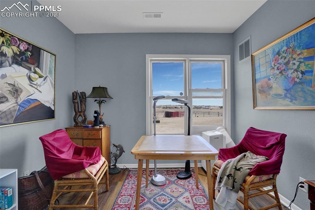 3805 Curtis Road Peyton, CO 80831 - Photo 22 of 48 a view of a dining room with furniture and wooden floor