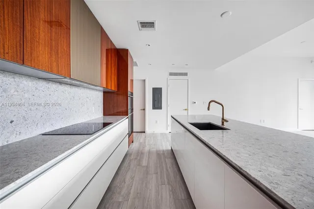 a kitchen with stainless steel appliances granite countertop a sink and a refrigerator