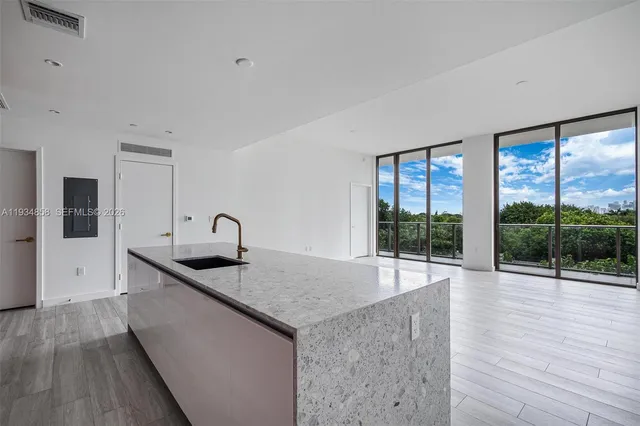 a kitchen with granite countertop a sink and a stove next to a window