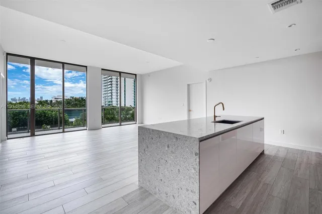 a kitchen with granite countertop a sink and a large window