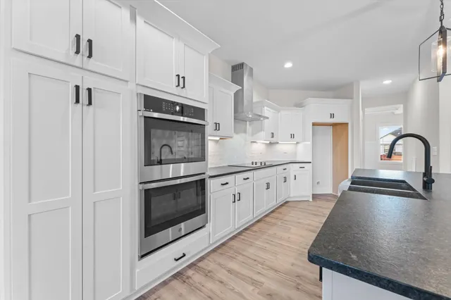 a kitchen with stainless steel appliances granite countertop a stove a sink and a microwave