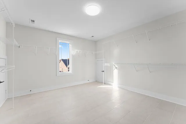 an empty room with windows and painted walls