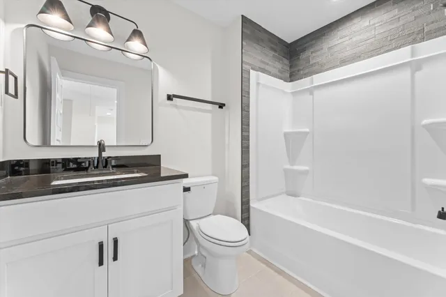 a bathroom with a sink a toilet a mirror and shower