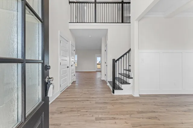 a view of a hallway with wooden floor and staircase