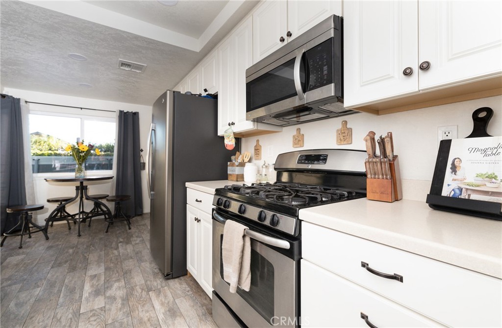 6667 King Street Chino, CA 91710 - Photo 7 of 21 a kitchen with stainless steel appliances granite countertop a stove a refrigerator and a microwave