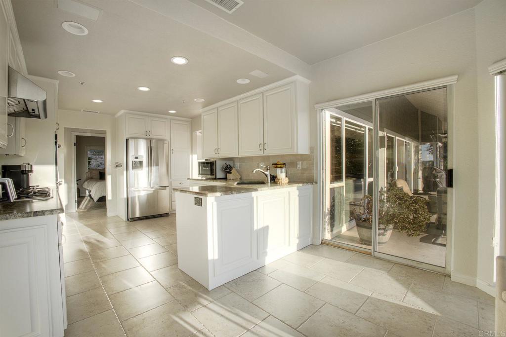 31220 Aquaduct Road Bonsall, CA 92003 - Photo 15 of 36 a kitchen with stainless steel appliances kitchen island granite countertop a refrigerator and a sink